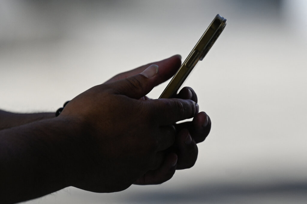 A man uses an Apple iPhone in Beijing on September 12, 2023. (Photo by Pedro PARDO/AFP).