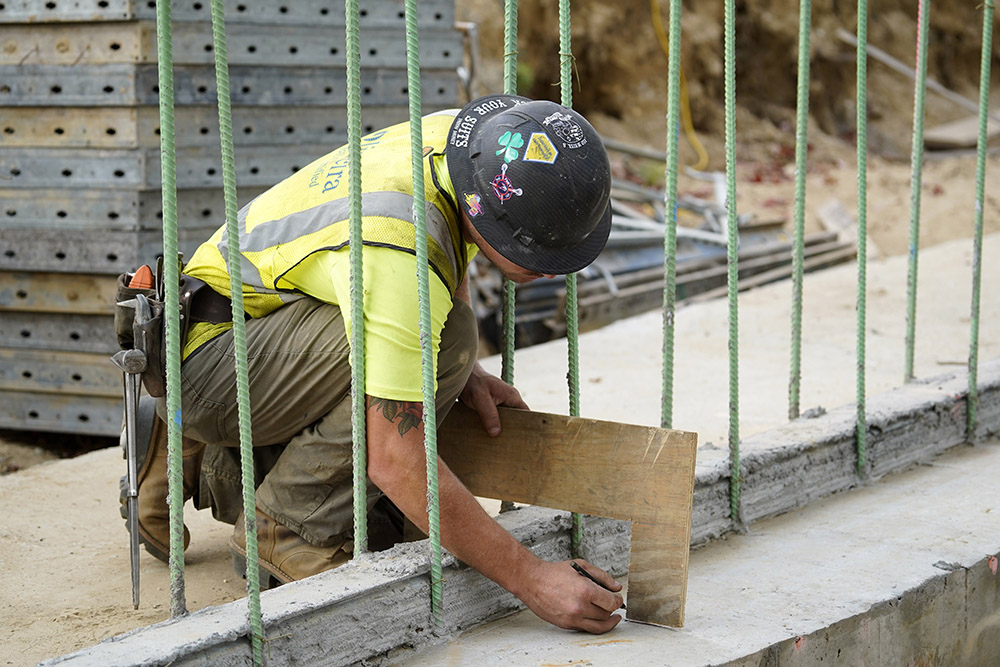 A worker takes a measurement at a highway construction site in Stony Brook, N.Y., Aug. 30, 2022. (CNS/Gregory A. Shemitz)