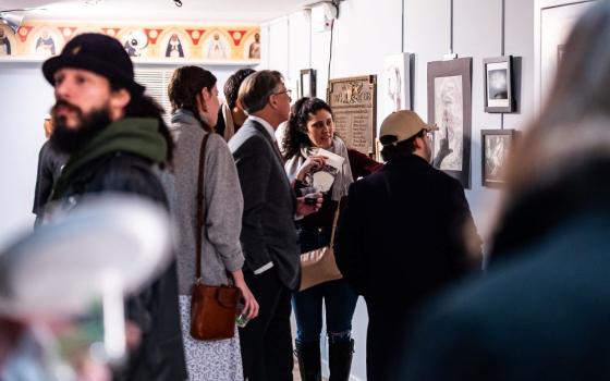 People view artwork on walls.