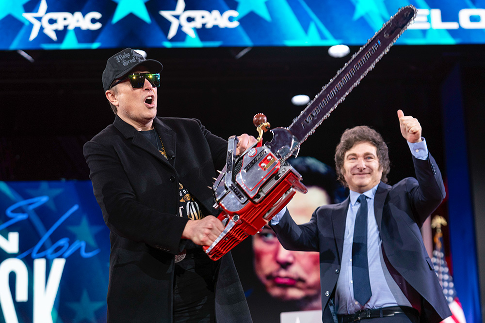 Elon Musk holds a chainsaw handed to him by Argentine President Javier Milei, behind, at the Conservative Political Action Conference (CPAC) in Oxon Hill, Maryland, Feb. 20, 2025. (AP/Jose Luis Magana)