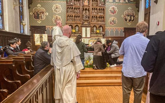 Dominican friars look on while people venerate what is believed to be the skull of St. Thomas Aquinas Nov. 30 in the chapel at the Dominican House of Studies in Washington. (NCR photo/ Carol Zimmermann)