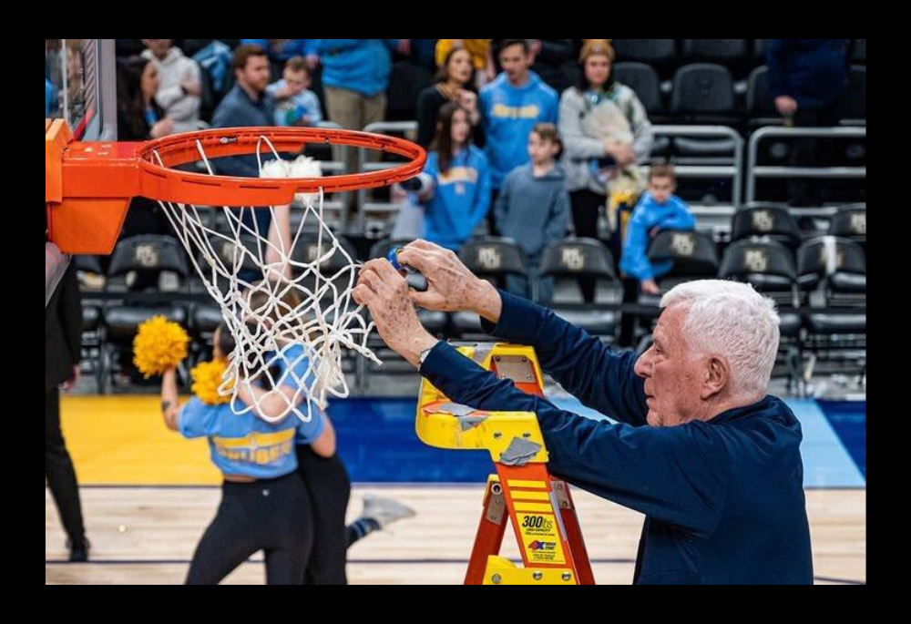 Marquette University basketball chaplain Jesuit Fr. John Laurance cuts the net in Madison Square Garden after the Golden Eagles men’s basketball team won the Big East Tournament in 2023. (Courtesy of Marquette Athletics)